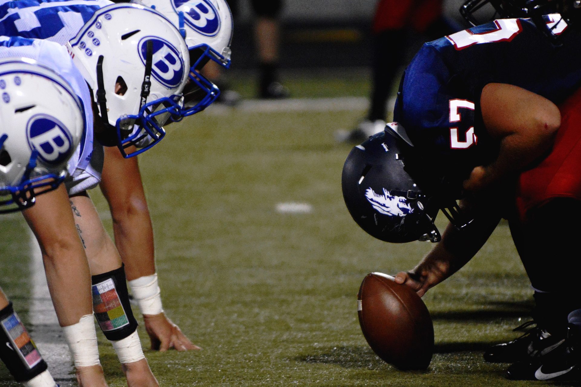 American football players lined up at the line of scrimmage, ready for the snap
